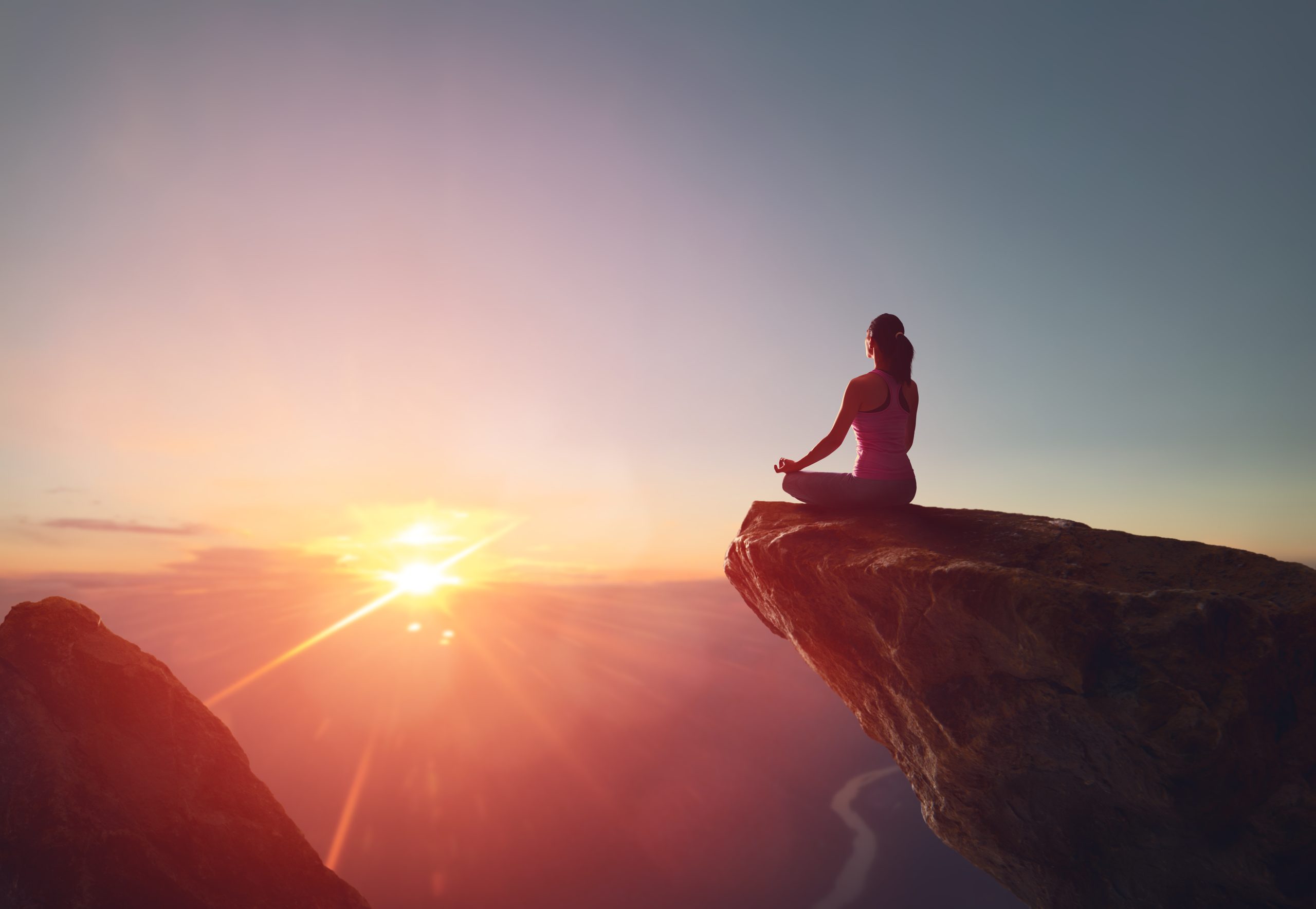 The Connection Between Spiritual Awakening and Mental Health Woman meditating yoga alone at sunrise mountains