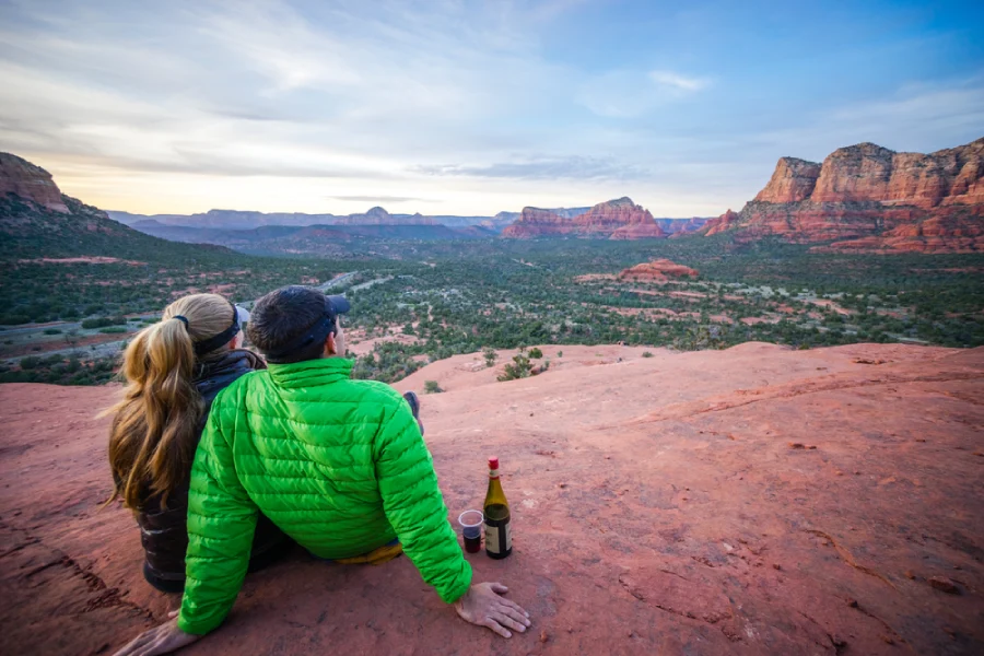 A couple sits together enjoying a gorgeous desert sunset in Sedona, AZ